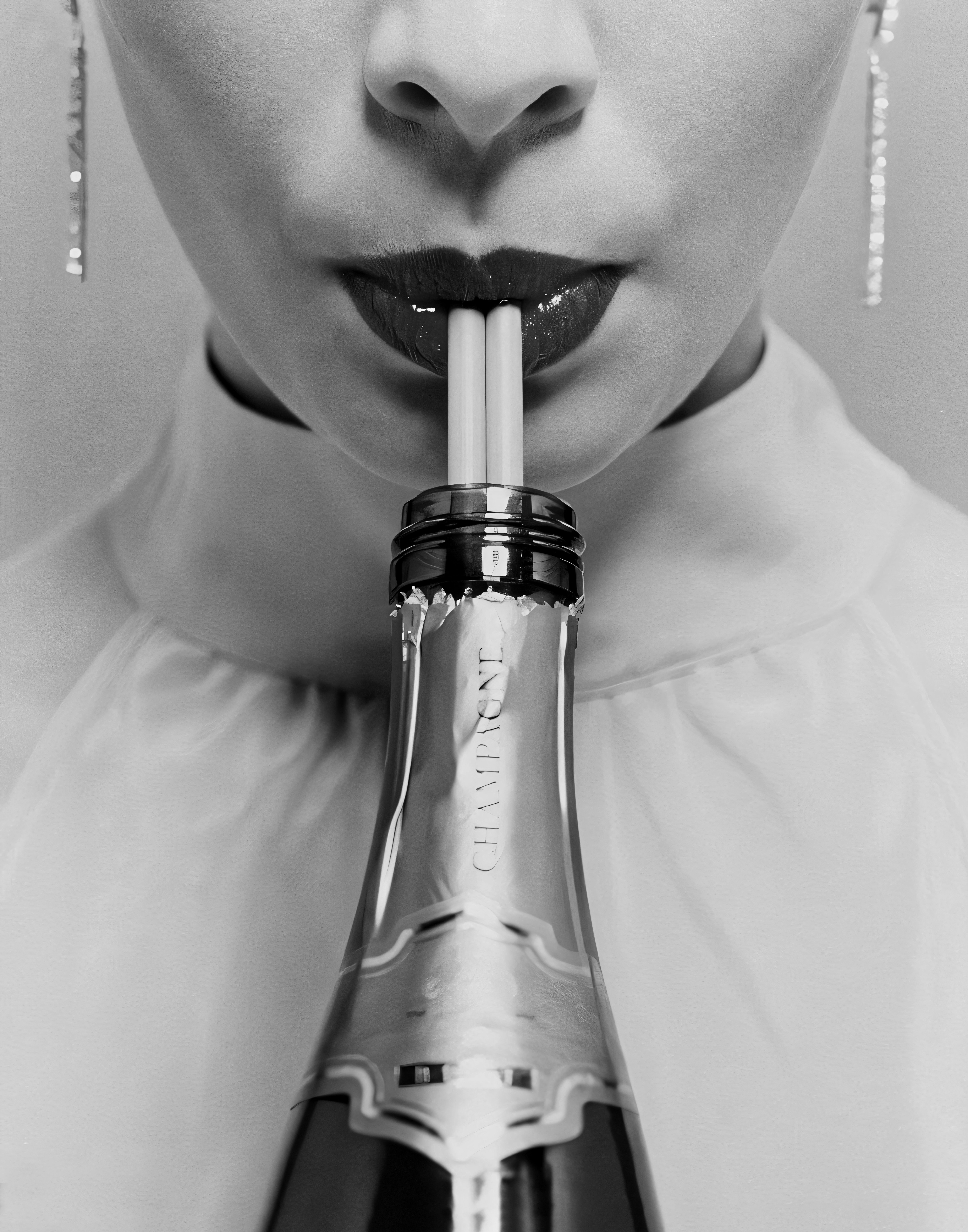A close-up portrait drinking champagne through straws